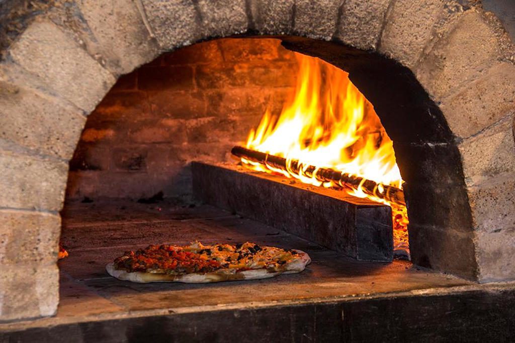 Pizza cooking in the brick oven at newest pizzeria, photo courtesy of Pizza en Leña