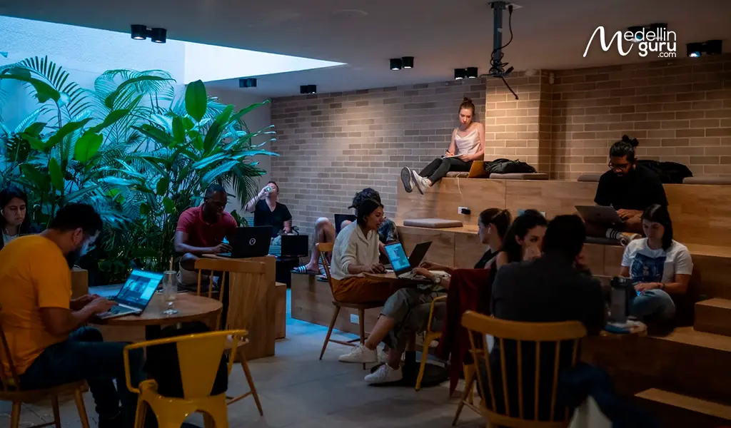 Digital nomads working on laptops in a modern coworking space in Medellín