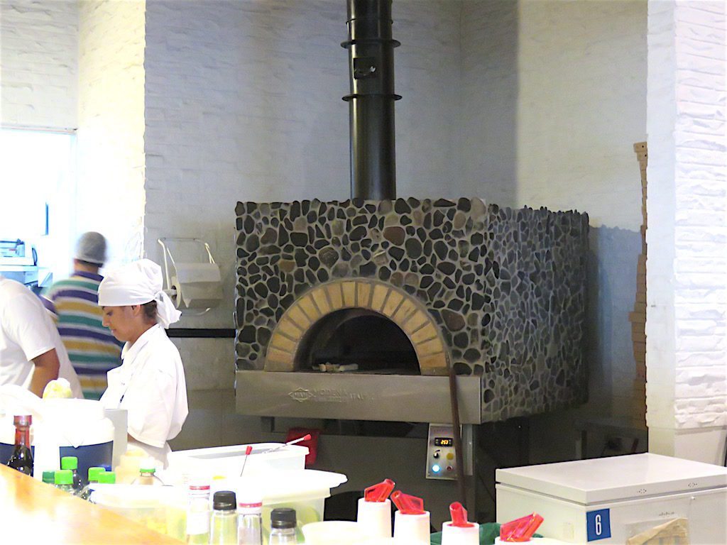Pizzas are cooked in brick ovens