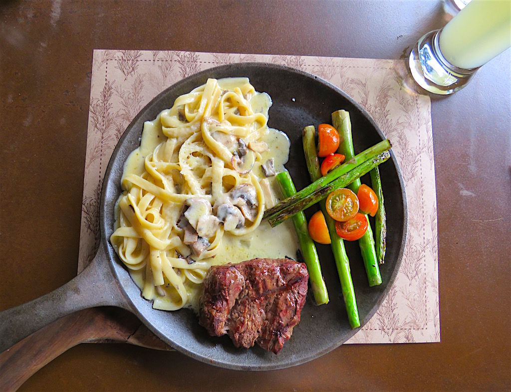 One of the mixed dishes with sirloin medallion, mushroom pasta in white sauce and asparagus