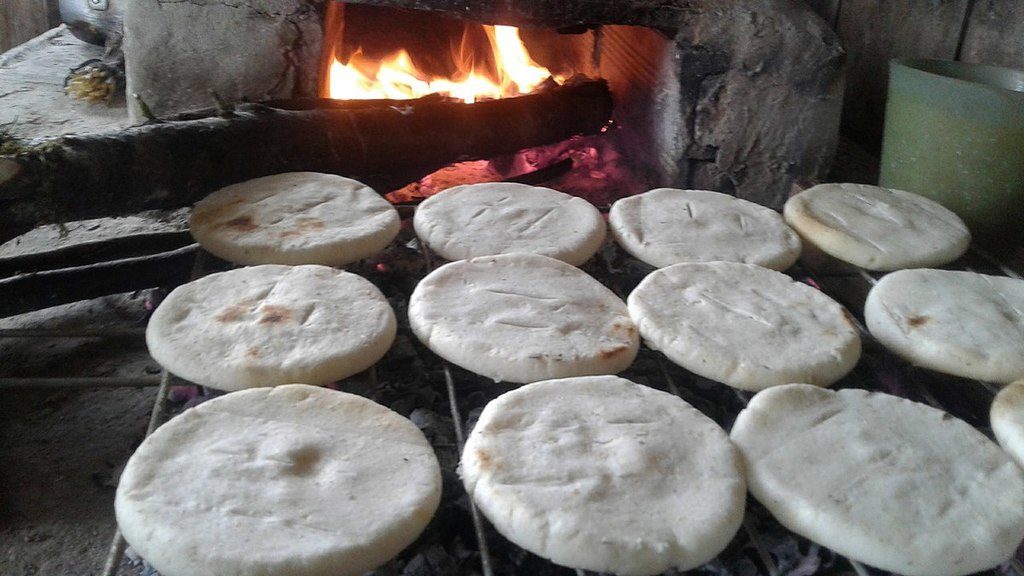 Arepas cooking on a wood-fired stove, photo by AmethystCosmos