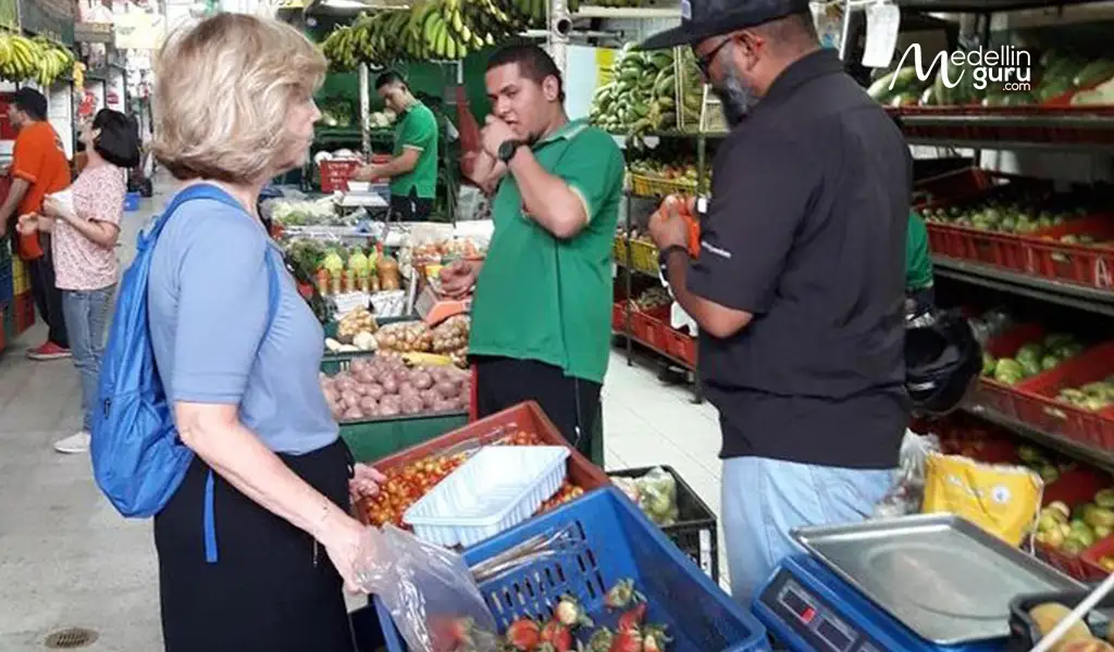 A person shopping for groceries in Medellín market, illustrating the 1.9% higher grocery prices compared to Bogotá.