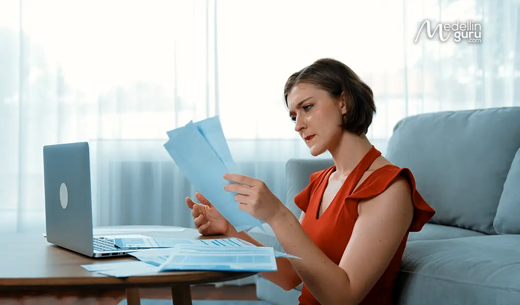 Frustrated digital nomad examining rejected Colombia Digital Nomad Visa application documents in 2025