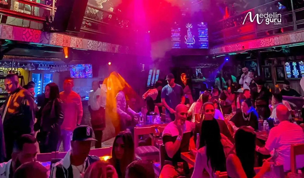 A vibrant photo of friends dancing together, capturing the lively atmosphere of a night out in Medellin. Photo by Two Travel