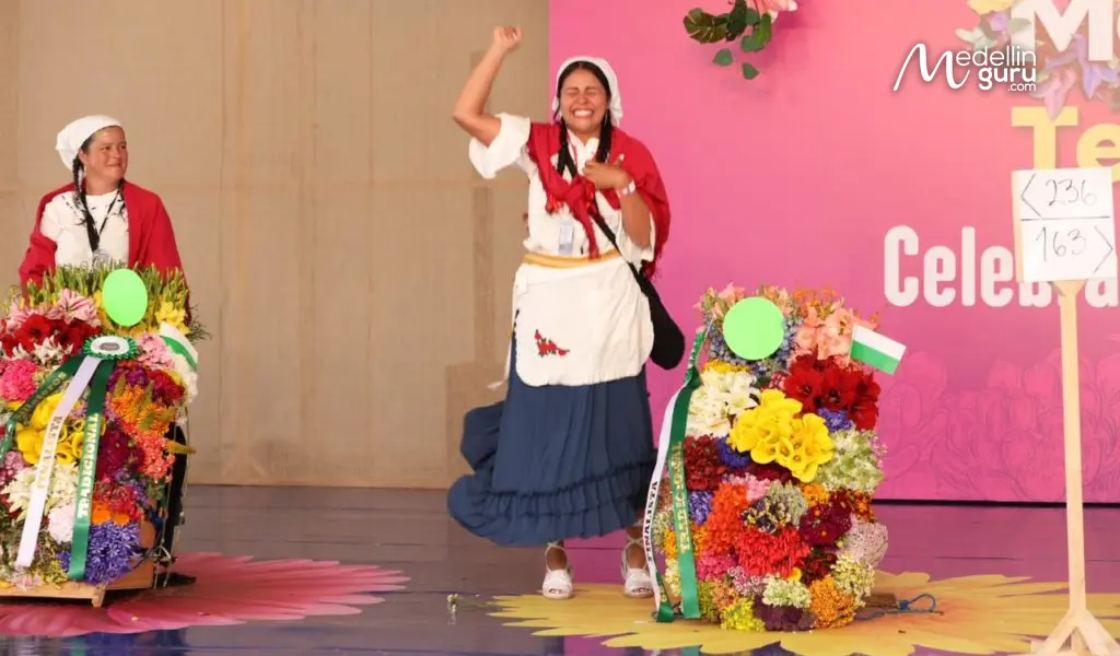 A happy silletera celebrating their silletas at the Medellín flower festiva, Photo via mioriente.com