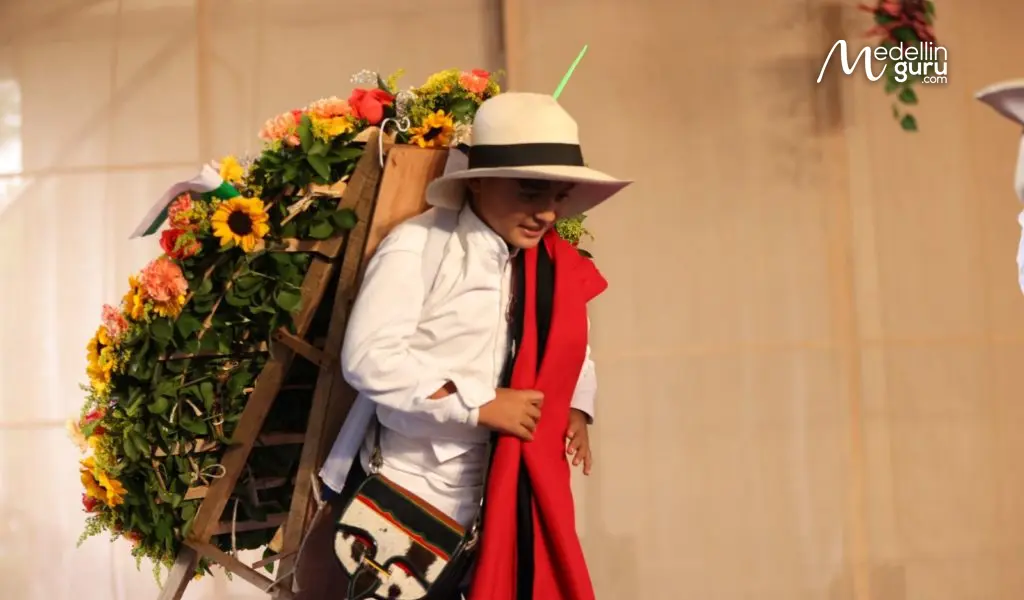 A young silletero proudly carries a silleta at the Desfile de Silleteros 2025, Photo via mioriente.com