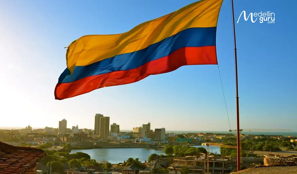 The Colombian flag flying over a city at sunset, symbolizing the dream of making Colombia your new home